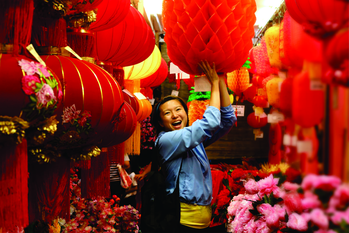 a woman holding a large red lantern