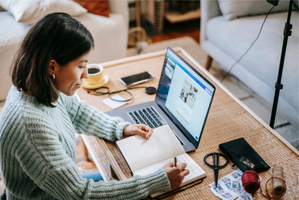 A woman focused on her laptop, working from the comfort of her home office, surrounded by a cozy environment.