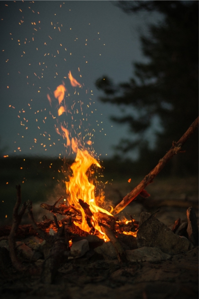 A warm bonfire flickers against a dark night sky